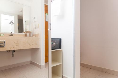 a bathroom with a sink and a mirror at Ocean View Cancun Arenas in Cancún