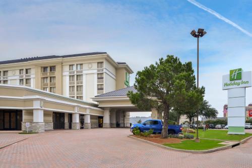 a hotel with a blue car parked in front of it at Holiday Inn Dallas-Richardson by IHG in Richardson