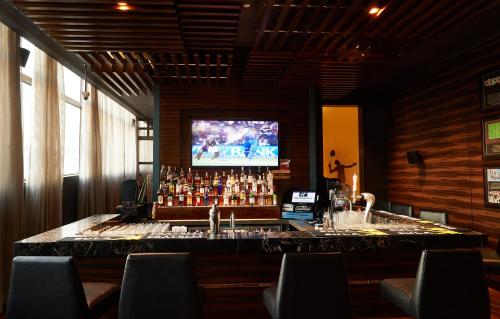 a bar in a restaurant with a tv above it at Holiday Inn Chennai OMR IT Expressway by IHG in Chennai