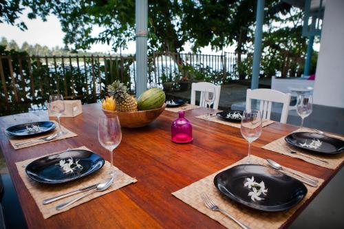 einen Holztisch mit Tellern und Weingläsern darauf in der Unterkunft Talalla Bay Beach House in Talalla