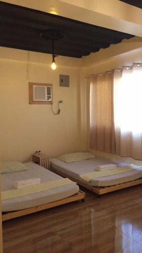 two beds in a room with a window at Location One Eighty in Bangcusay