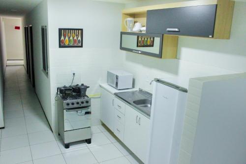 uma pequena cozinha com um fogão e um lavatório em Pousada Residencial Milagre 02 em Juazeiro do Norte