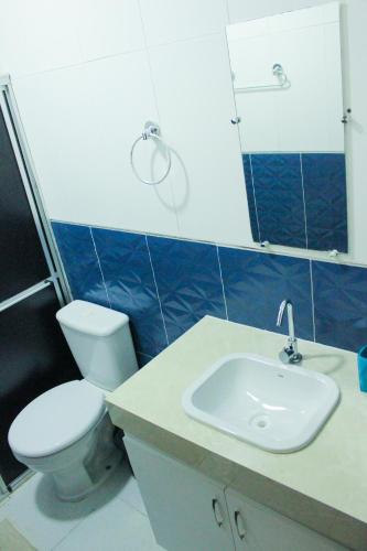 a bathroom with a toilet and a sink at Pousada Residencial Milagre 02 in Juazeiro do Norte