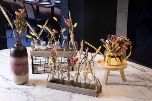 a group of vases with flowers in them on a table at Maison 46 in Paris