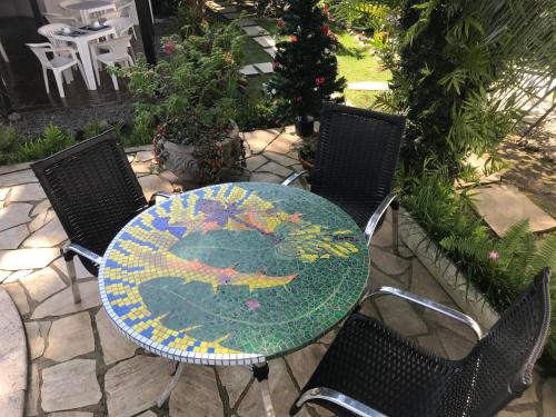 a glass table with two chairs and a table with at Pousada Chalé Suíço in Paraty