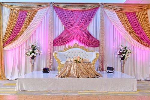 a pink and gold stage with a table and a chair at Holiday Inn Dallas-Richardson by IHG in Richardson