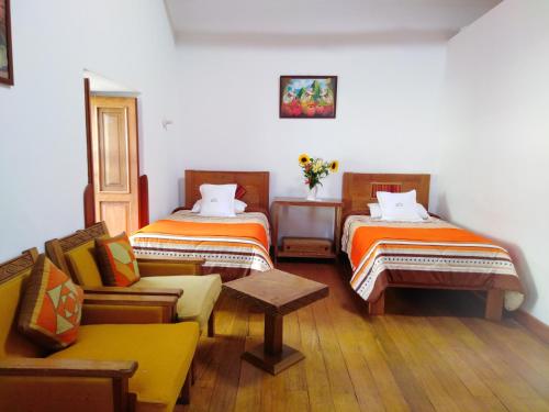 Habitación con 2 camas y sofá. en Casa San Pedro Cusco, en Cusco