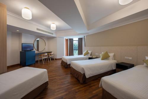 a hotel room with two beds and a mirror at YWCA Fort Canning in Singapore