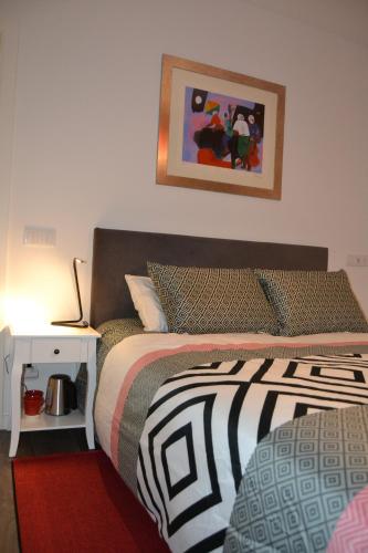 1 dormitorio con 1 cama y una foto en la pared en Casa do Mouro, en Lousã