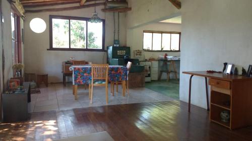 uma cozinha e sala de jantar com mesa e cadeiras em Canto do Jacarandá (Casa no Vale do Matutu) em Aiuruoca