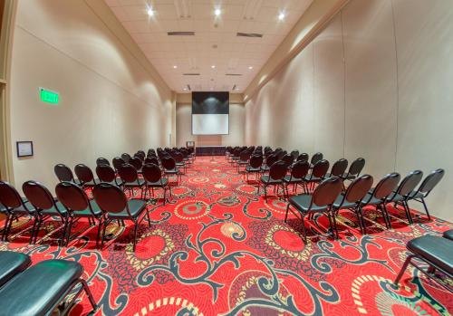 a conference room with chairs and a screen in it at Holiday Inn Des Moines-Airport Conf Center by IHG in Des Moines