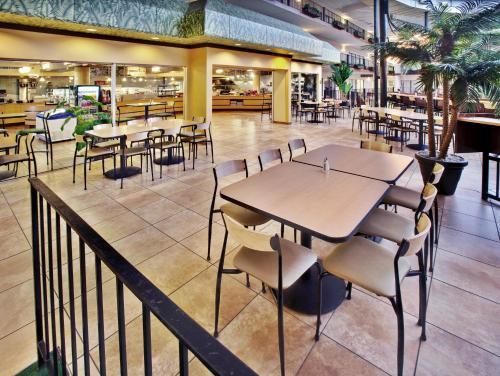 a restaurant with tables and chairs in a cafeteria at Holiday Inn Des Moines-Airport Conf Center by IHG in Des Moines