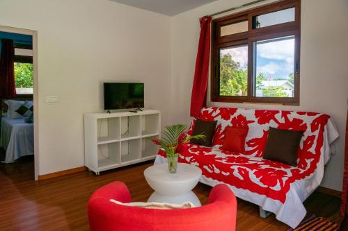 a living room with a red couch and two chairs at Kovailani 1232 DTO-MT in Bora Bora