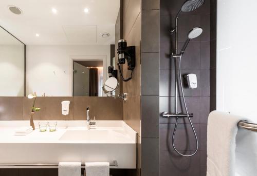 a bathroom with a sink and a shower at Holiday Inn Dresden - Am Zwinger by IHG in Dresden