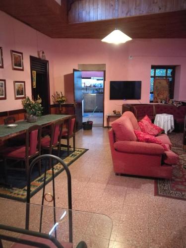 a living room with a red couch and a table at Residencia Los Conejos - Bike & Motorbike in Las Palmas de Gran Canaria