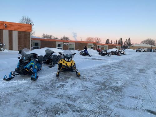 two motorcycles parked in a parking lot in the snow at Valley Inn Motel in Sudbury