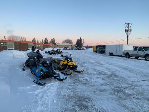 two snow motorcycles parked on a snow covered street at Valley Inn Motel in Sudbury