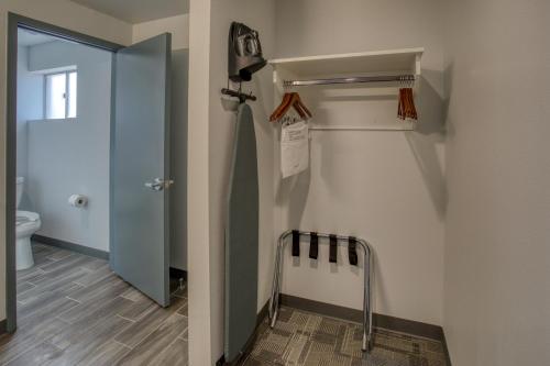 a bathroom with a toilet and a door to a room at Post Time Inn in Carlsbad