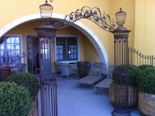a patio with an arch with a bench and a table at Appart's Village Trama Loges in Puymirol