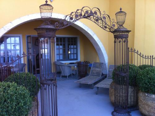 d'une terrasse avec une arche, un banc et une table. dans l'établissement Appart's Village Trama Loges, à Puymirol