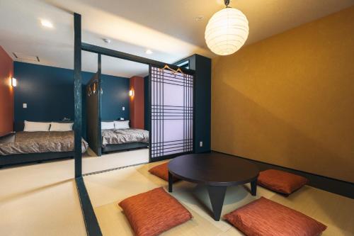 a room with two beds and a table in a room at KINGYO - Doyanen Hotels in Osaka