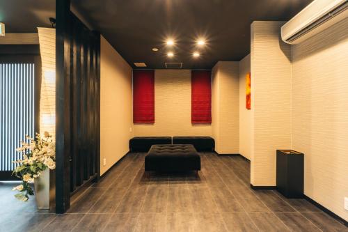 a waiting room with a couch and red curtains at KINGYO - Doyanen Hotels in Osaka