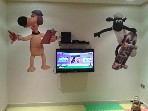 a room with stuffed animals and a tv on the wall at أسوار للشقق المخدومة in Al Khobar