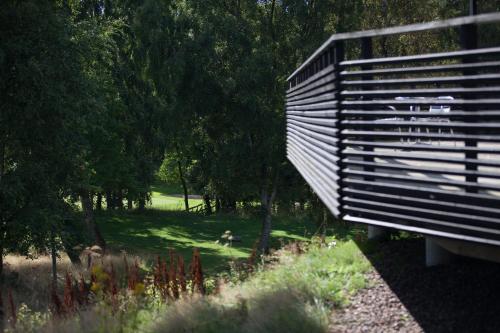 a wooden bridge in a park with trees and grass at Tylebäck Hotell & Konferens, BW Signature Collection in Halmstad