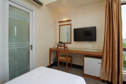 a bedroom with a desk with a television and a bed at Kepong Hotel in Kuala Lumpur