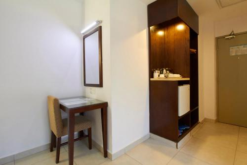 Habitación con mesa, espejo y puerta en Kepong Hotel, en Kuala Lumpur