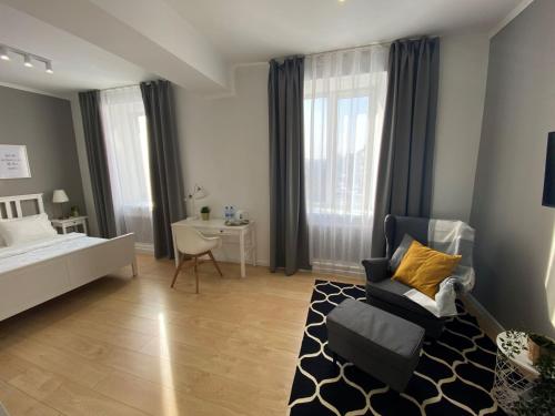 a bedroom with a bed and a chair and a desk at Zarya Lux Hotel in Prokop'yevsk