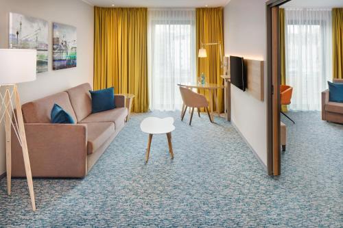 a living room with a couch and a table at Holiday Inn Düsseldorf City – Toulouser Allee by IHG in Düsseldorf