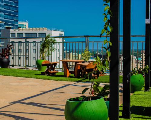 a park with a table and benches and a building at Holiday Inn Dar Es Salaam by IHG in Dar es Salaam