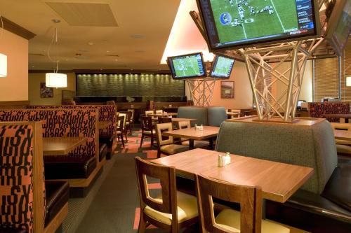 a restaurant with tables and chairs and a flat screen tv at Holiday Inn Denver Lakewood by IHG in Lakewood