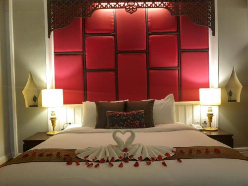 a bedroom with a large bed with a red headboard at Le Palais Juliana in Luang Prabang