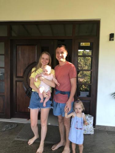 a man and woman holding a baby in front of a door at Kandyan Lounge in Kiribatkumbura