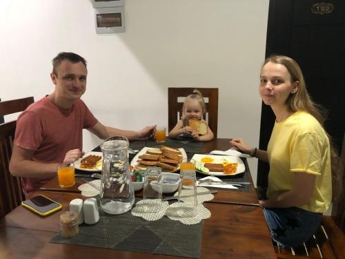 a man and a woman sitting at a table with food at Kandyan Lounge in Kiribatkumbura