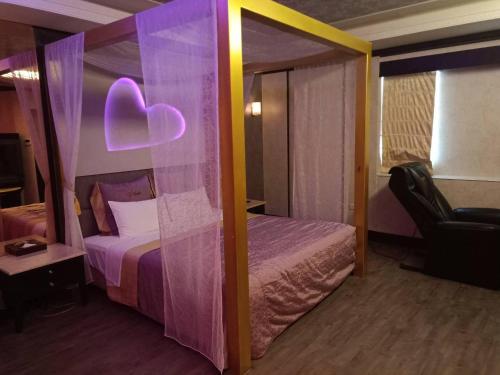 Dormitorio con cama con dosel y corazón en Xin Yuan Motel, en Taichung