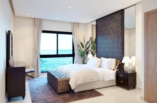 a bedroom with a large bed and a large window at Apartment 004 - Mina Al Fajer in Fujairah