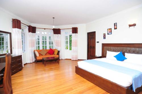 a bedroom with a bed and a couch in it at Ireby Tea Estate Bungalow in Hatton