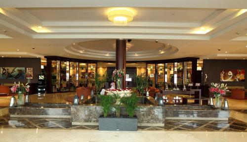 a lobby of a hotel with a counter with flowers at Holiday Inn Al Khobar - Corniche by IHG in Al Khobar
