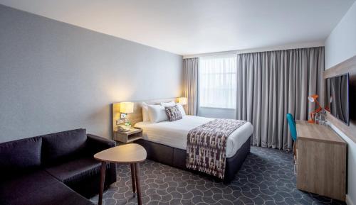 a hotel room with a bed and a couch at Holiday Inn Ellesmere Port/Cheshire Oaks by IHG in Ellesmere Port
