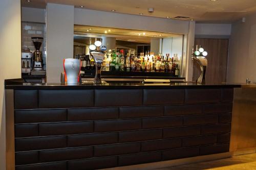a bar in a hotel with a lot of drinks at Holiday Inn Ellesmere Port/Cheshire Oaks by IHG in Ellesmere Port