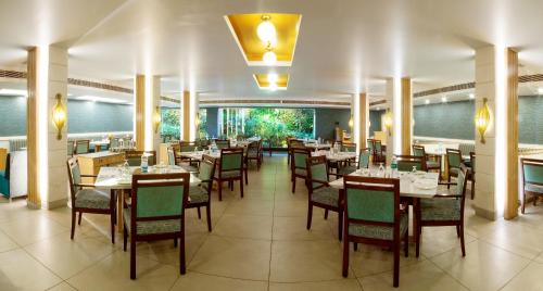 ティルチラーパッリにあるRamyas Hotelsのレストラン内のダイニングルーム(テーブル、椅子付)