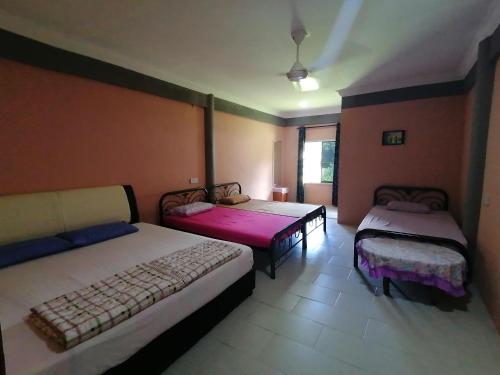 - une chambre avec 2 lits et une fenêtre dans l'établissement Mulu Diana Homestay, à Mulu