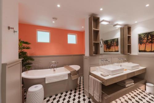 a bathroom with two sinks and a bath tub at LUX* Grand Gaube Resort & Villas in Grand Gaube