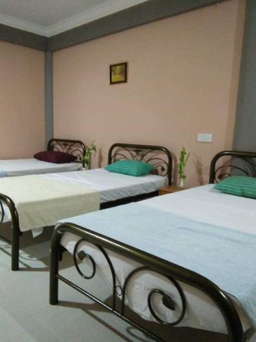 a room with three beds in a room at Mulu Diana Homestay in Mulu
