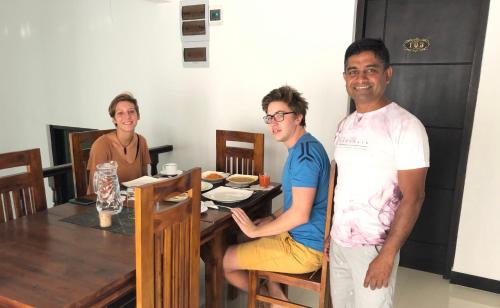 a group of three people standing in front of a table at Kandyan Lounge in Kiribatkumbura
