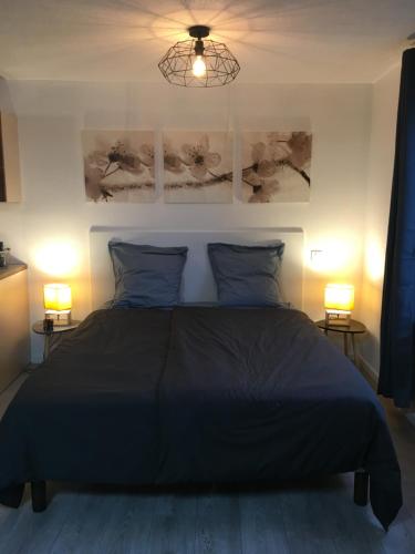 - une chambre avec un lit noir et deux lampes dans l'établissement Appartement tout confort, avec terrasse, à Niederbronn-les-Bains