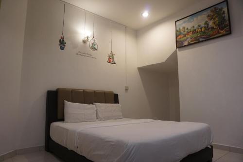a bedroom with a large bed with white sheets at S & S Guest House Kuantan in Kuantan